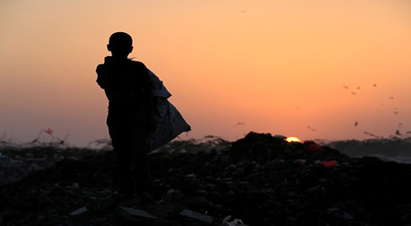 Ayoub Mohammed Ruzaiq, 11, stands in a garbage dump
